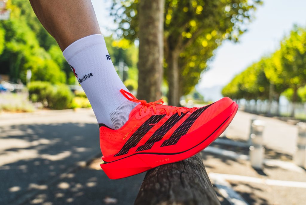 chaussure de running rouge avec trois bandes noires